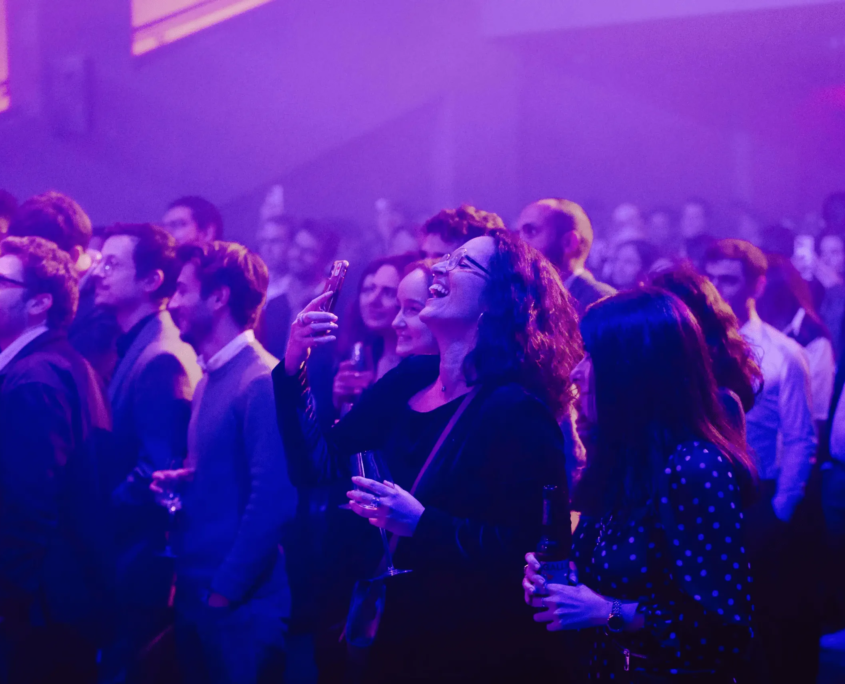 Grupo de pessoas em um evento social com luz roxa e azul suave