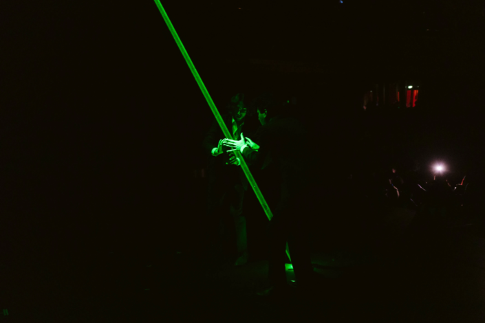 Imagem de duas pessoas usando um laser verde grande.