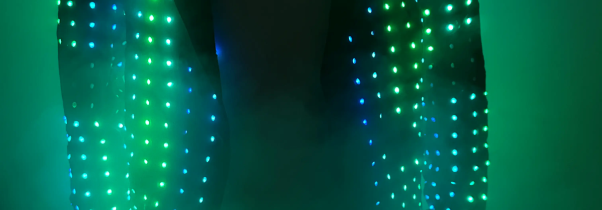 Áo khoác LED tương tác chiếu sáng rực rỡ đồng bộ với âm nhạc trên sân khấu biểu diễn.