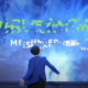 Mann auf der Bühne interagiert mit immersiver Technologie