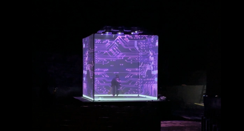 Man inside a luminous cube surrounded by violet tech visuals